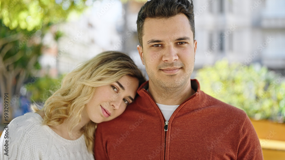 Man and woman couple standing together with relaxed expression at park Man and woman couple standing together with relaxed expression at park