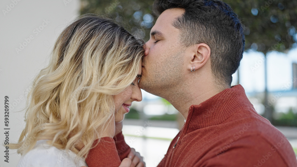 Man and woman couple smiling confident kissing on head at street Man and woman couple smiling confident kissing on head at street