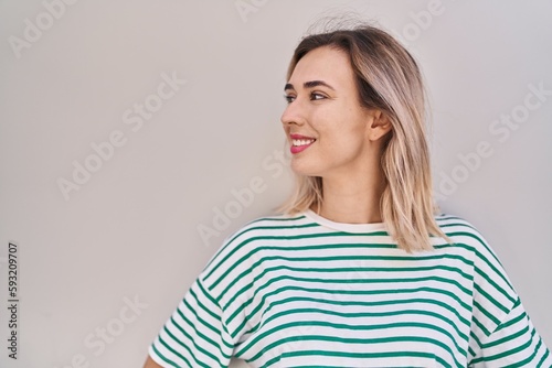 Young woman smiling confident looking to the side over white isolated background