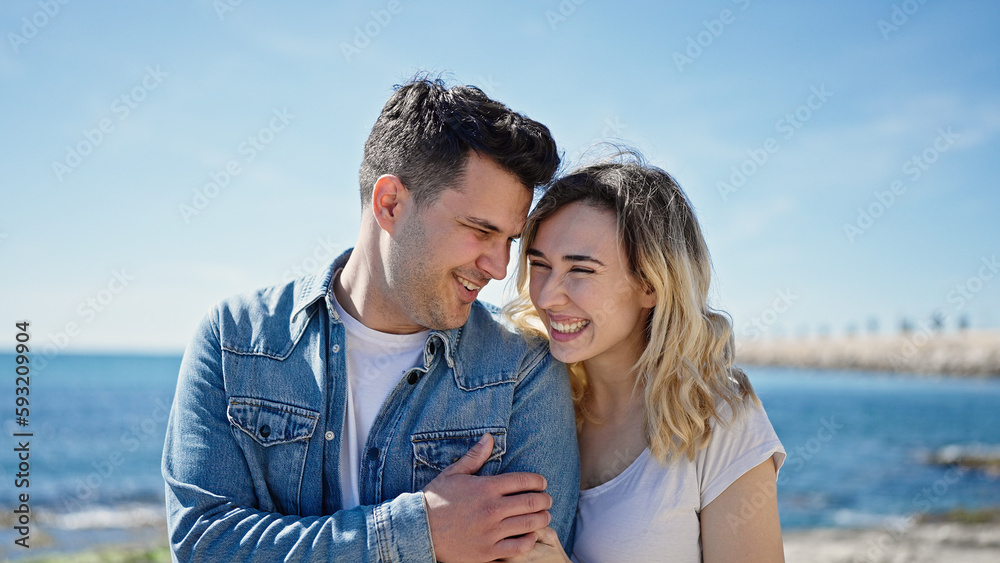 Man and woman couple smiling confident hugging each other at seaside Man and woman couple smiling confident hugging each other at seaside