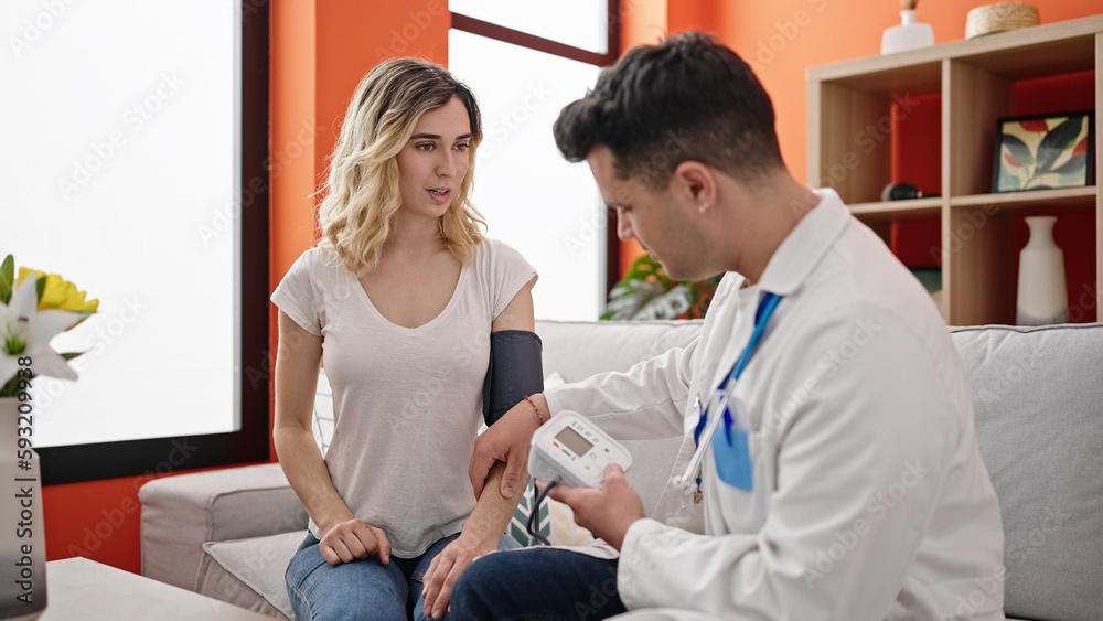 Fototapeta premium Man and woman doctor and patient measuring pulse using tensiometer at home