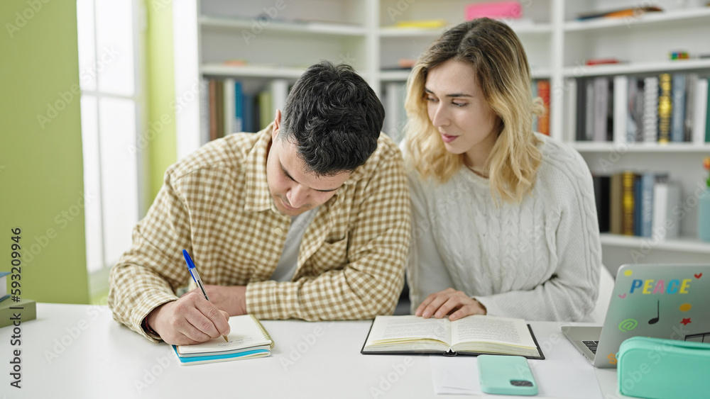 Man and woman students studying together at library university Man and woman students studying together at library university