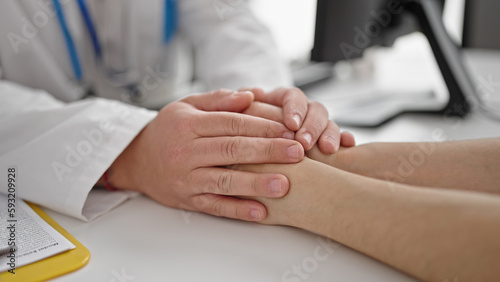 Man and woman doctor and patient supporting with hands together at clinic