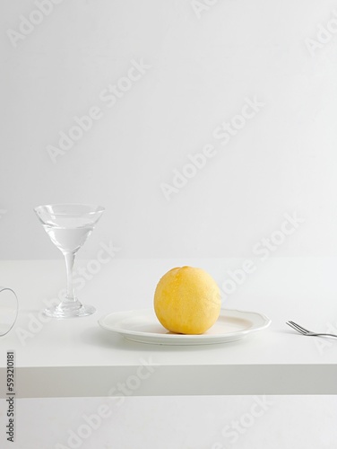 Minimalistic decorated table with a yellow peach on a plate