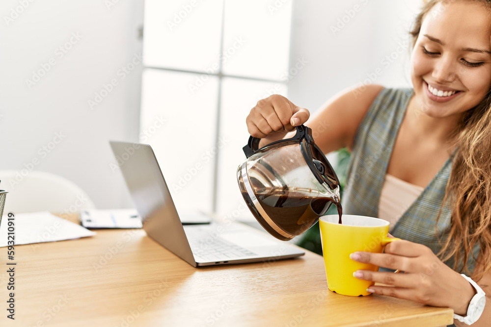 Young beautiful hispanic woman business worker pouring coffee on cup working at office Young beautiful hispanic woman business worker pouring coffee on cup working at office