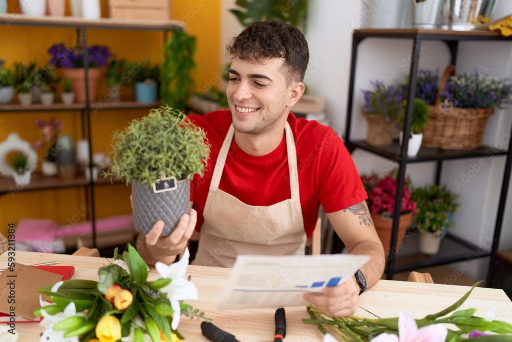 Young hispanic man florist reading document holding plant at flower shop Young hispanic man florist reading document holding plant at flower shop