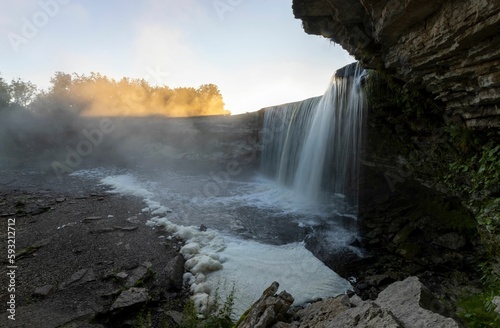 Beautiful scenery of the Jagala waterfall during a misty sunrise in Estonia