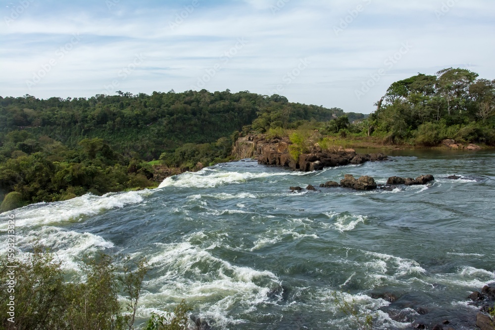 Obraz premium Landscape scene of Iguazu waterfalls with wood trees with blue sky in Argentina