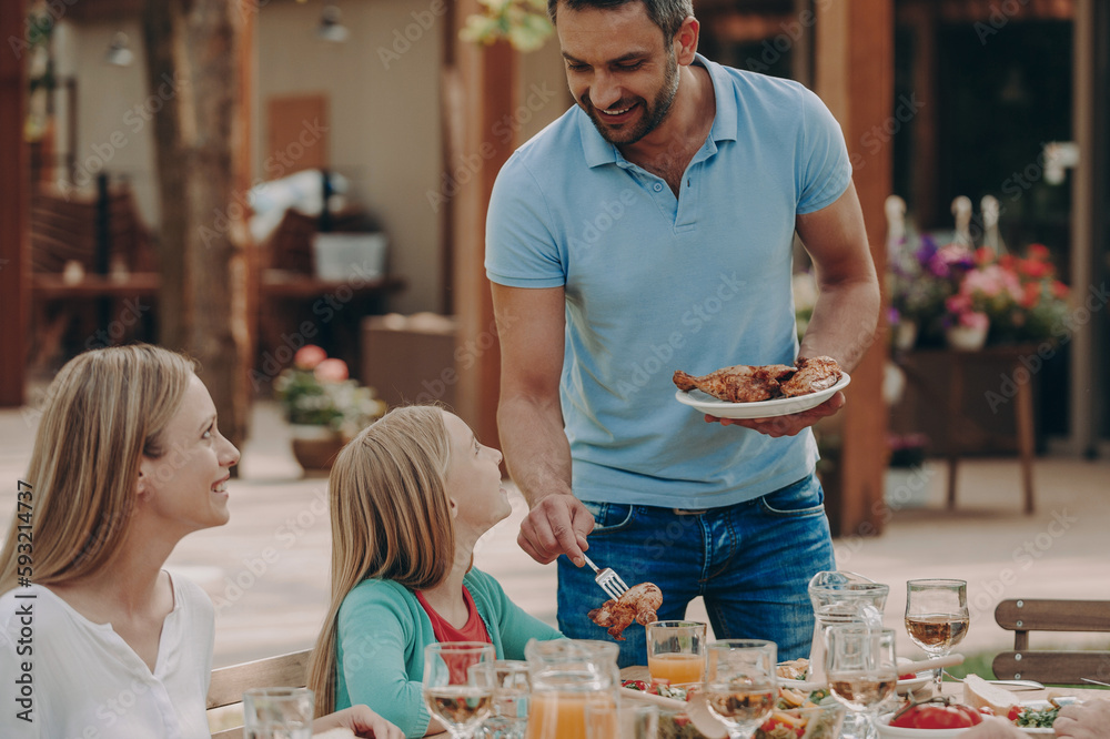 Happy family enjoying their meal while having dinner outdoors together Happy family enjoying their meal while having dinner outdoors together