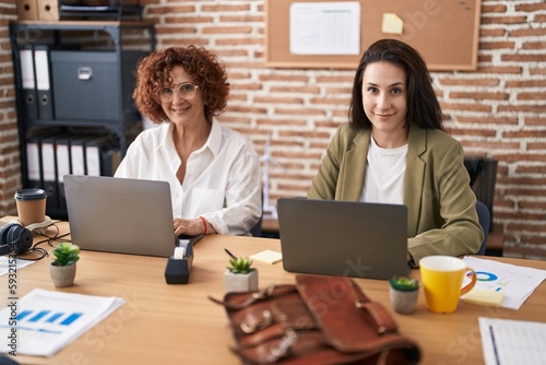 Two women business workers using laptop working at office