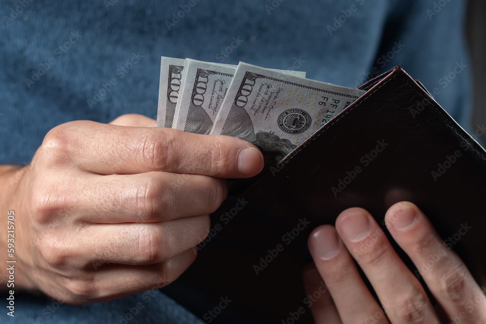 Hands holding us dollar bills and money pouch. Hands holding us dollar bills and money pouch.