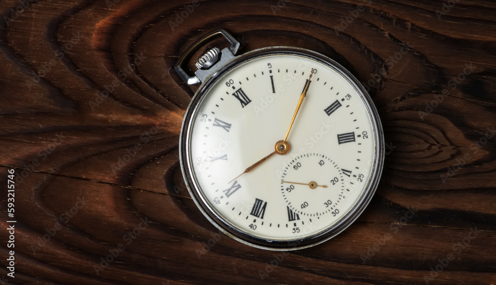 Antique pocket watch on a wood board Antique pocket watch on a wood board