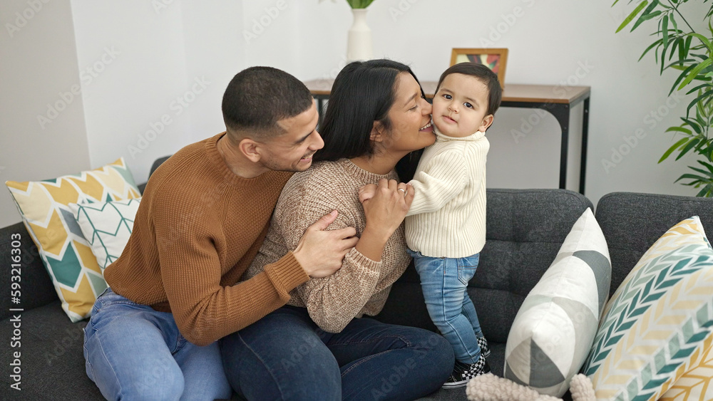 Couple and son hugging each other sitting on sofa at home Couple and son hugging each other sitting on sofa at home