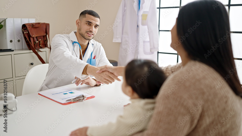 Couple and son smiling confident shake hands at clinic Couple and son smiling confident shake hands at clinic