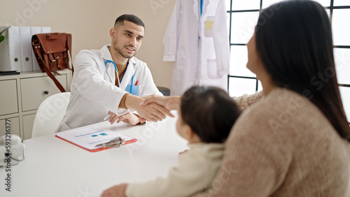 Couple and son smiling confident shake hands at clinic