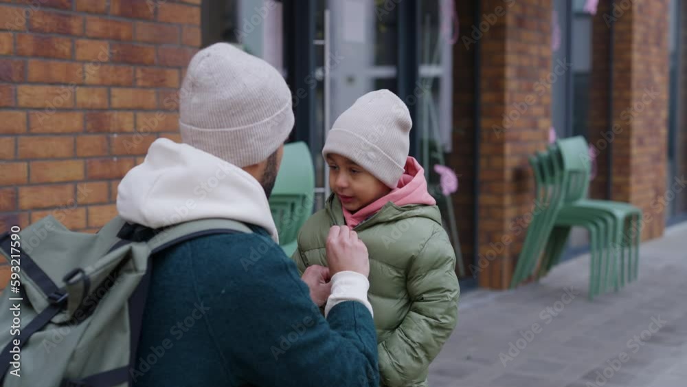 Father button up jacket to his little son. Father button up jacket to his little son.