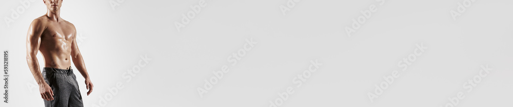 Fototapeta premium Unrecognizable muscular man with perfect torso standing against white background