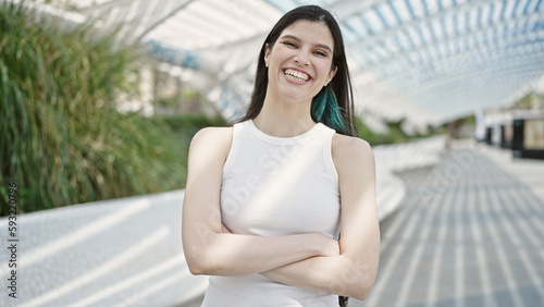 Young beautiful hispanic woman standing with crossed arms at park Free Download Young beautiful hispanic woman standing with crossed arms at park - GFXLoad