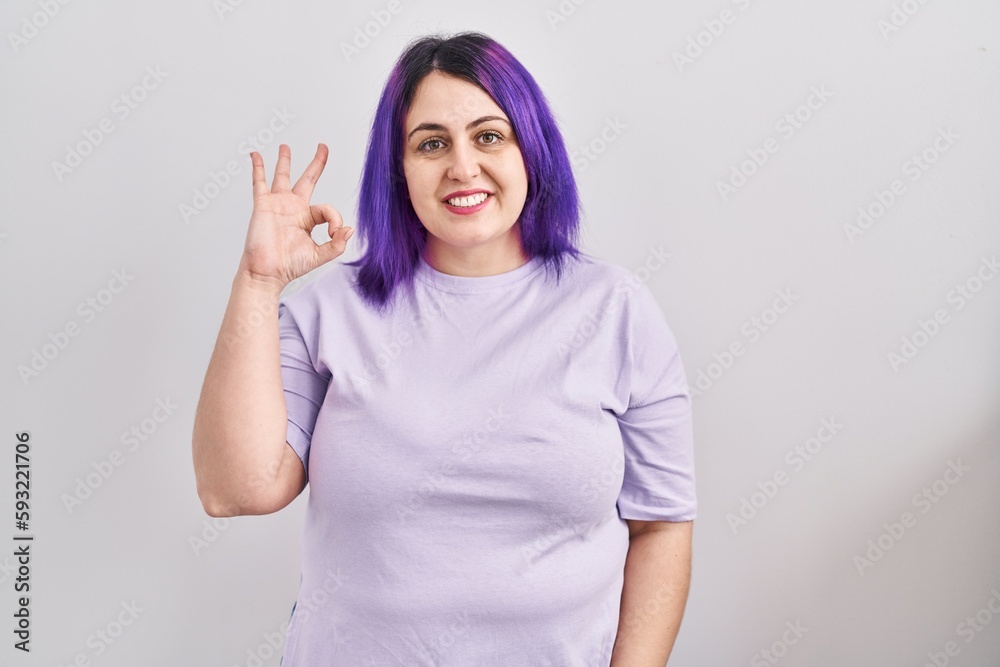 Plus size woman wit purple hair standing over isolated background smiling positive doing ok sign with hand and fingers. successful expression. - obrazy, fototapety, plakaty 