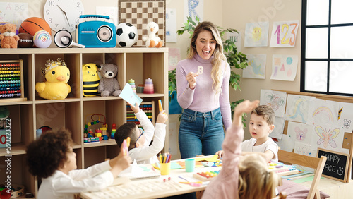 Woman and group of kids having vocabulary lesson at kindergarten