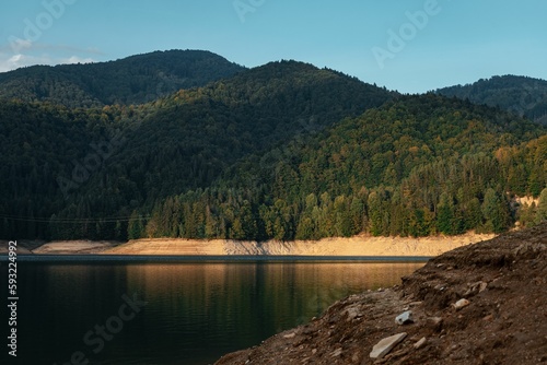 Fototapeta Naklejka Na Ścianę i Meble -  Landscape of a lake surrounded by dense green mountain forests