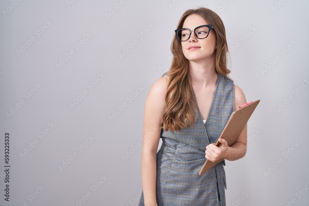 Caucasian woman wearing glasses and business clothes looking away to side with smile on face, natural expression. laughing confident. Caucasian woman wearing glasses and business clothes looking away to side with smile on face, natural expression. laughing confident.