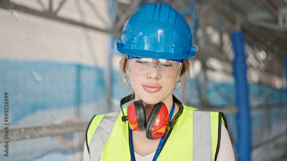 Young blonde woman architect standing with relaxed expression at street