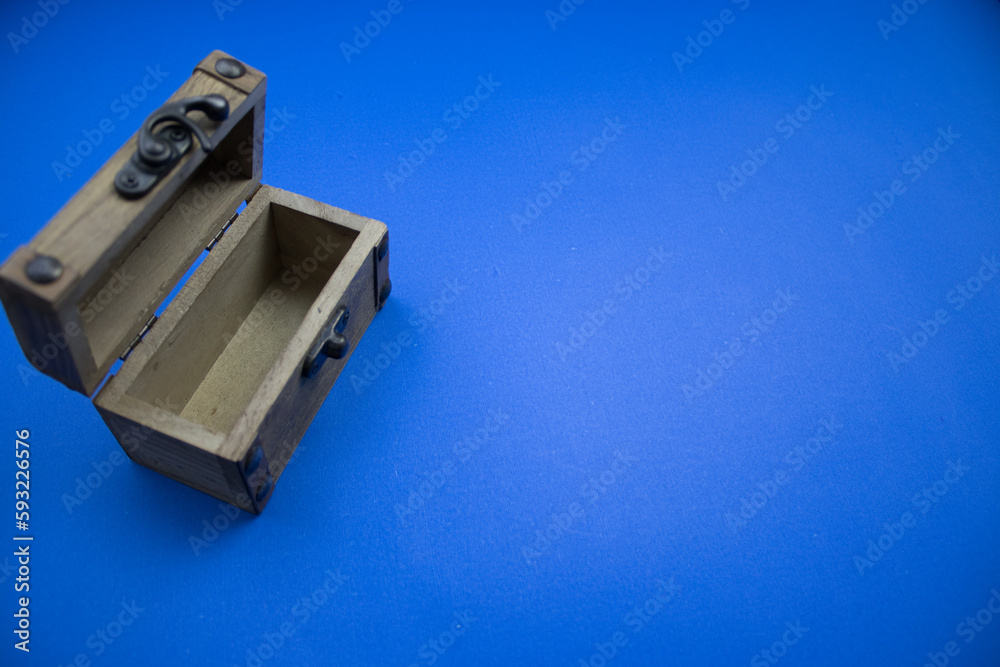 Fototapeta premium Wooden, open chest, placed on a blue background, photographed from above.