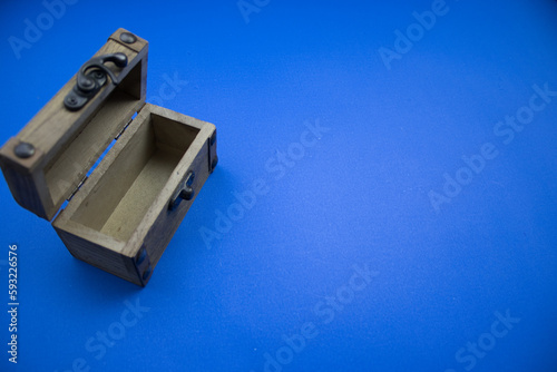 Wooden, open chest, placed on a blue background, photographed from above.