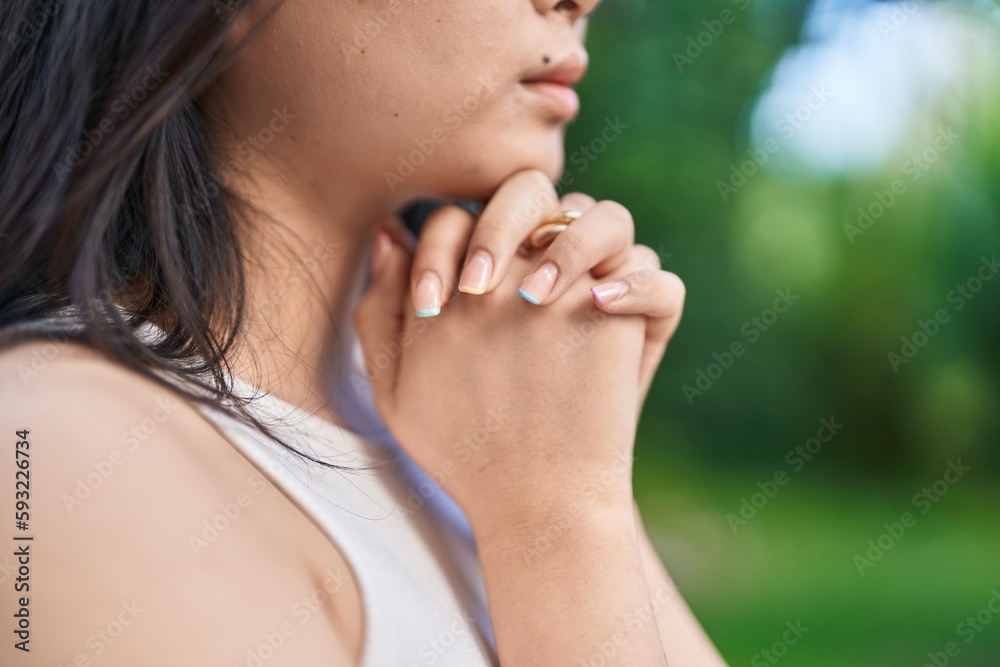 Young chinese woman praying with closed eyes at park Young chinese woman praying with closed eyes at park