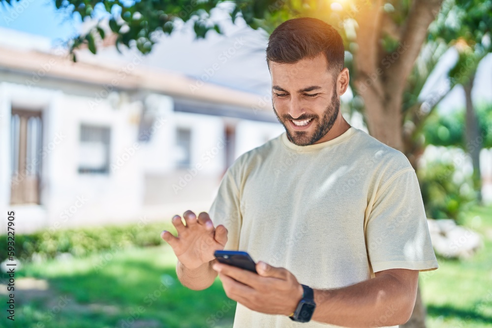 Young hispanic man smiling confident using smartphone at park Young hispanic man smiling confident using smartphone at park
