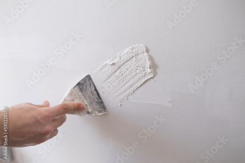 repairing walls with putty and spatula photo