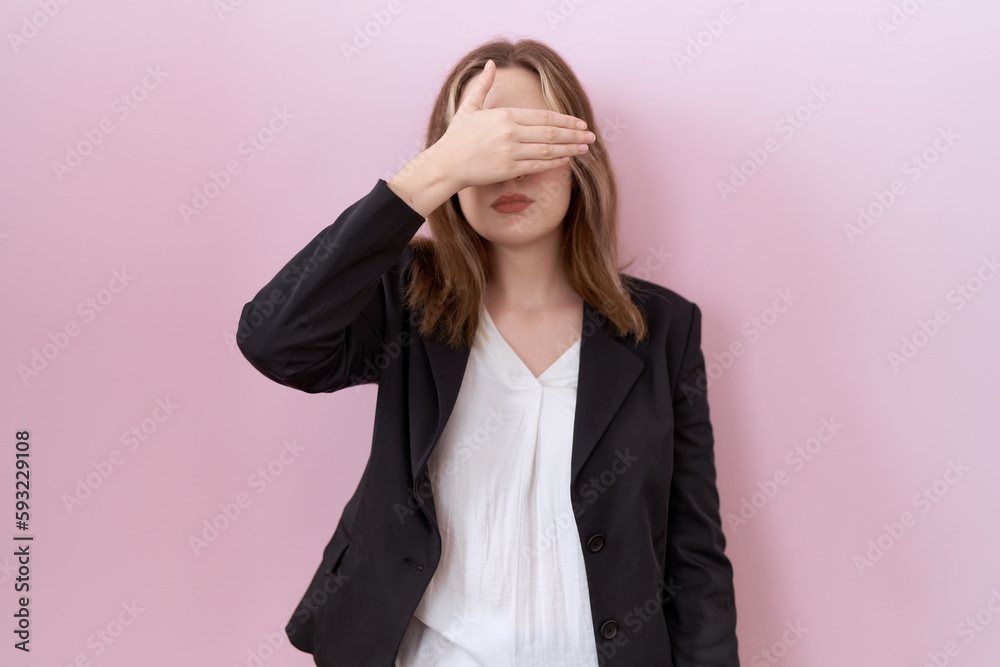 Young caucasian business woman wearing black jacket covering eyes with hand, looking serious and sad. sightless, hiding and rejection concept Young caucasian business woman wearing black jacket covering eyes with hand, looking serious and sad. sightless, hiding and rejection concept