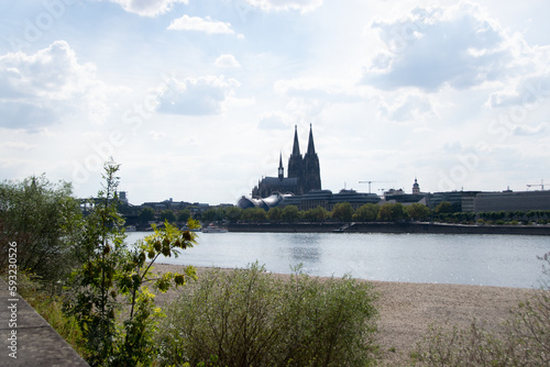 Blick auf den Rhein und den Dom in Köln, mit Treibgut Müll im Vordergrund auf ausgetrocknetem Flussbett im Hochsommer 2022.