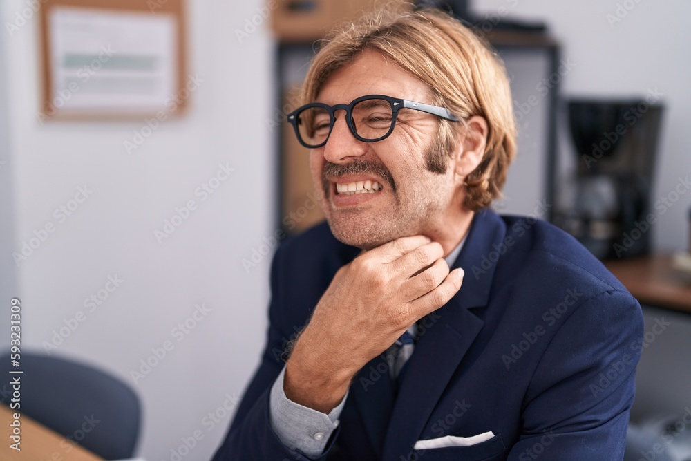 Young blond man business worker suffering for throat pain working at office Young blond man business worker suffering for throat pain working at office