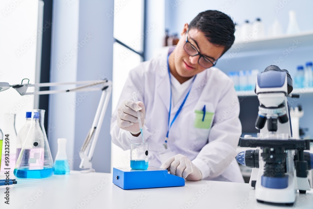 Down syndrome man wearing scientist uniform measuring liquid at laboratory Down syndrome man wearing scientist uniform measuring liquid at laboratory