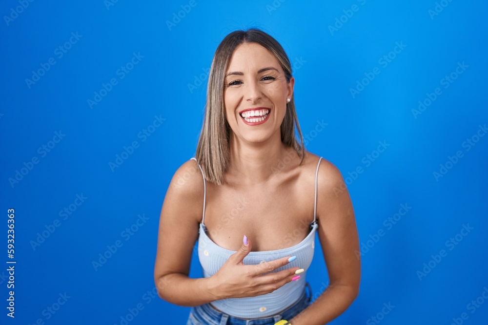 Young woman standing over blue background smiling and laughing hard out loud because funny crazy joke with hands on body. Young woman standing over blue background smiling and laughing hard out loud because funny crazy joke with hands on body.