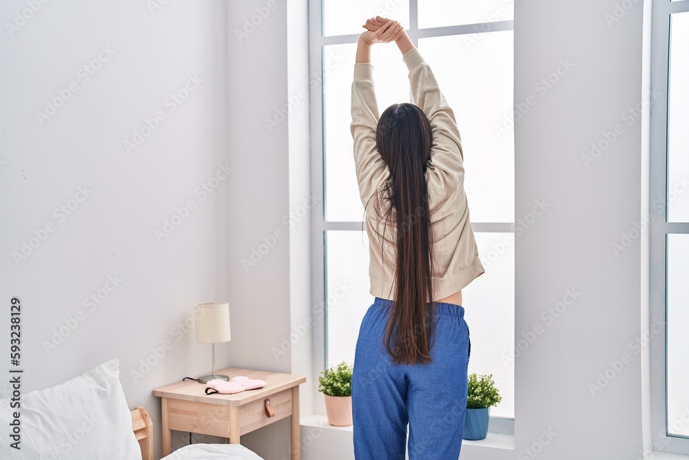 Chinese woman waking up stretching arms at bedroom Chinese woman waking up stretching arms at bedroom
