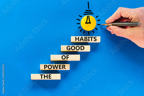 The power of good habits symbol. Concept words The power of good habits on wooden block. Beautiful blue table blue background. Businessman hand. Business the power of good habits concept. Copy space.