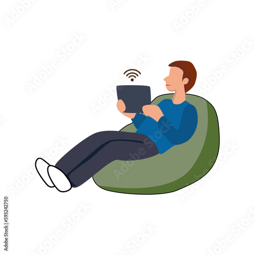 Young boy sitting and watching movie on tablet computer on sofa