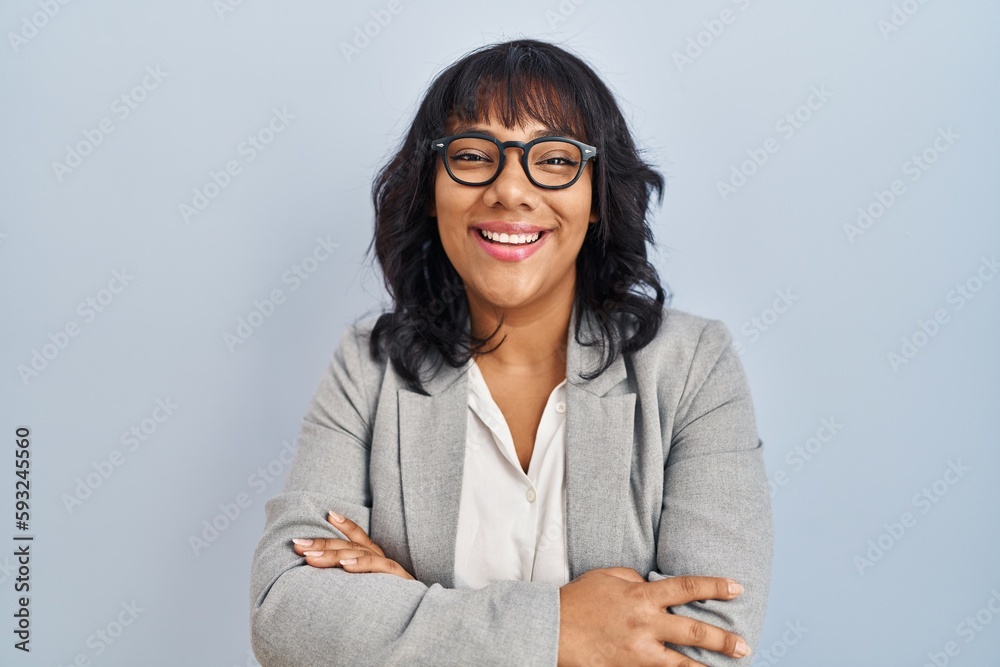 Hispanic woman standing over isolated background happy face smiling with crossed arms looking at the camera. positive person. Hispanic woman standing over isolated background happy face smiling with crossed arms looking at the camera. positive person.