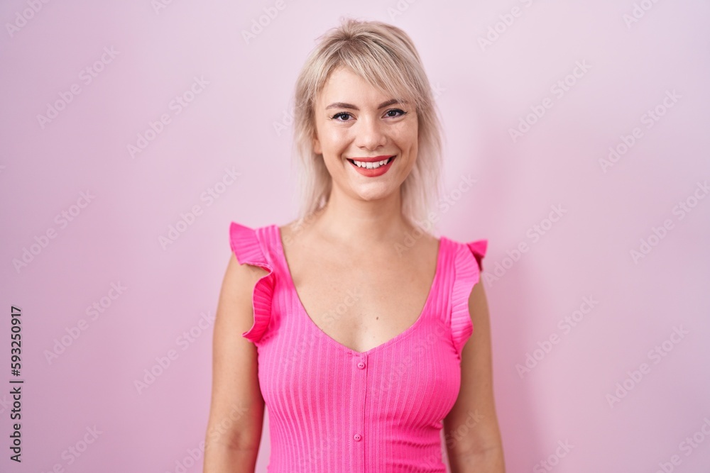 Young caucasian woman standing over pink background with a happy and cool smile on face. lucky person. Young caucasian woman standing over pink background with a happy and cool smile on face. lucky person.