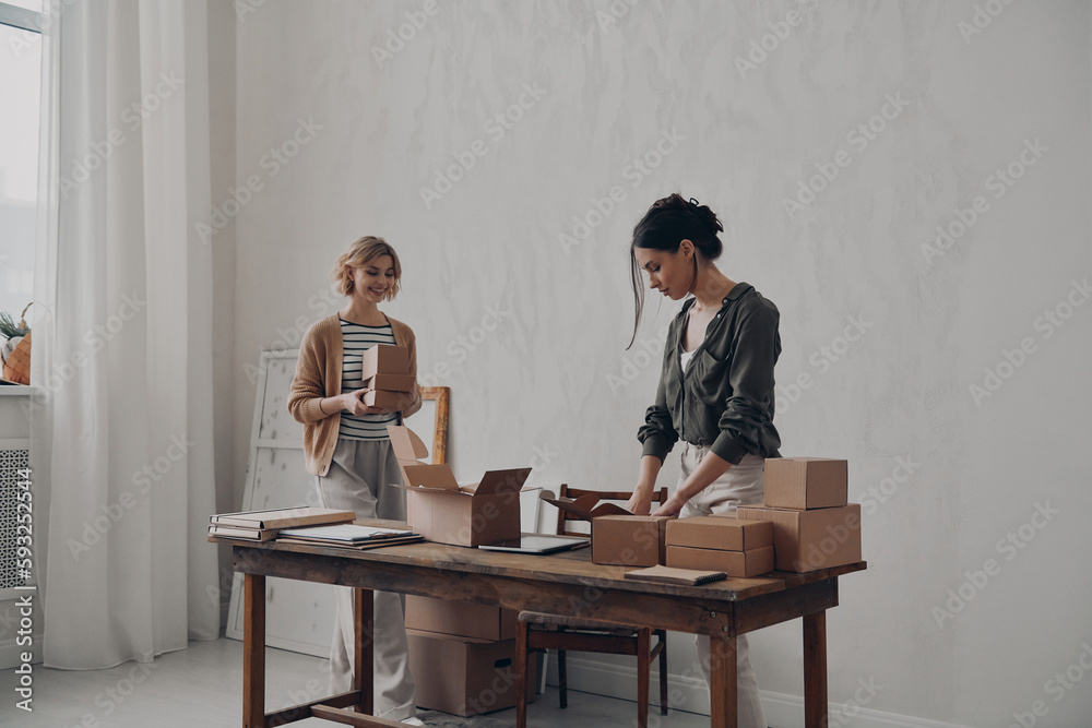 Two confident businesswomen preparing packages for delivery in warehouse Two confident businesswomen preparing packages for delivery in warehouse