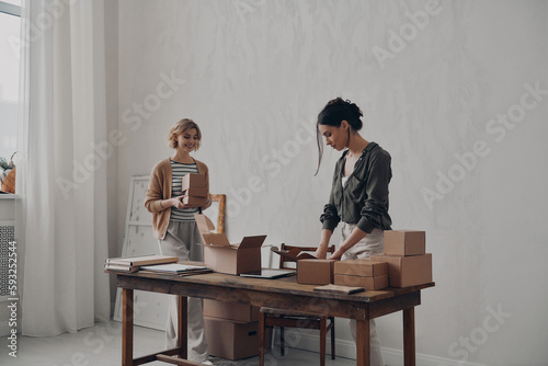 Wallpaper Mural Two confident businesswomen preparing packages for delivery in warehouse Torontodigital.ca