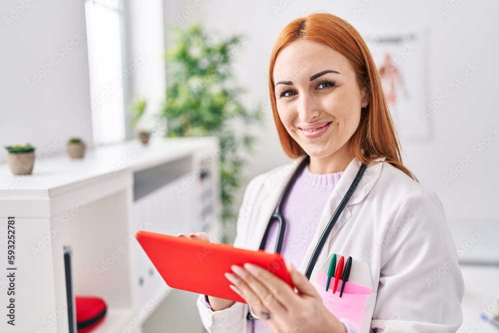 Young caucasian woman doctor using touchpad standing at clinic Young caucasian woman doctor using touchpad standing at clinic