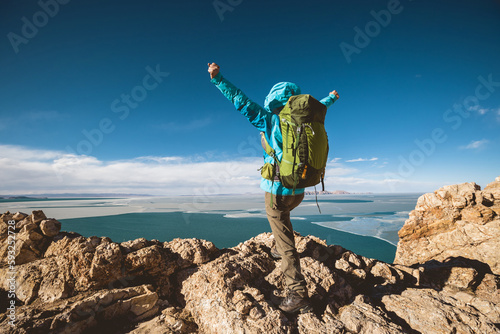 Woman hiker enjoy the ivew on mountain top cliff ege at lakeside photo