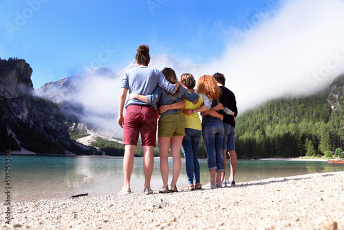 Group of friends of different nationalities on vacation on a mountain lake in the middle of nature, take selfie and celebrate spring or summer © fabrus