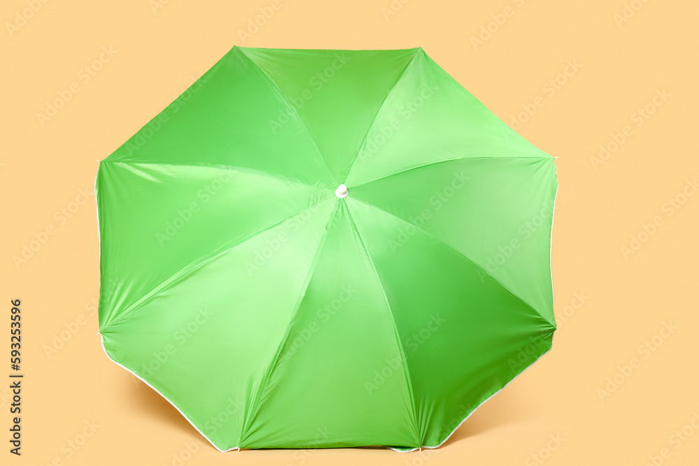 Green beach umbrella on beige background Green beach umbrella on beige background