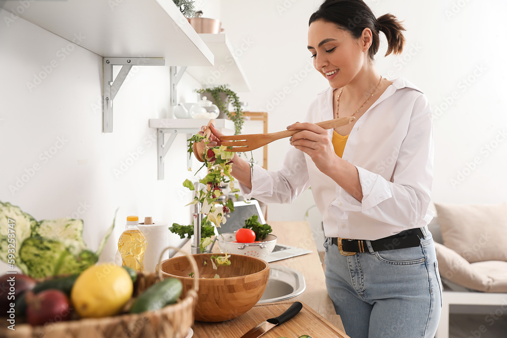 Young woman making vegetable salad in kitchen Young woman making vegetable salad in kitchen