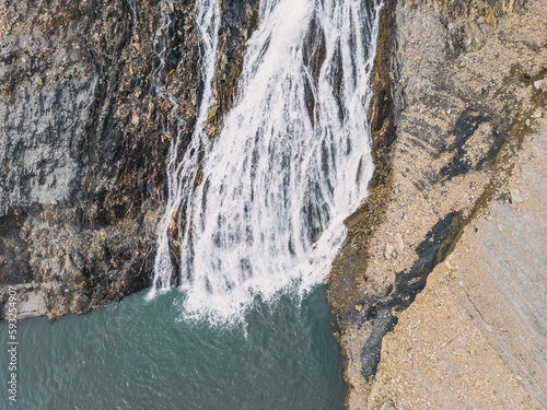 Panoramic drone shot of a waterfall flowing into Lac Chambon in French Alps